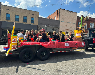 A cheerful group of individuals on a decorated float, participating in a festive parade